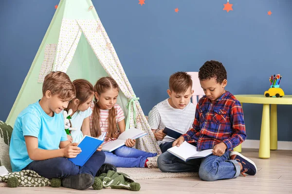 Niedliche kleine Kinder lesen Bücher drinnen — Stockfoto