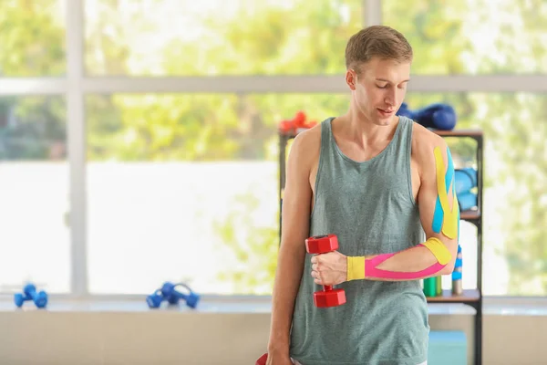 Sporty man with physio tape training in gym — Stock Photo, Image