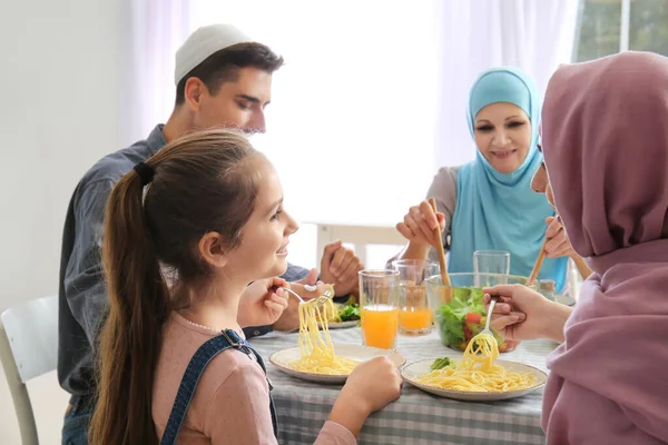 Müslüman bir aile evde yemek yiyor.