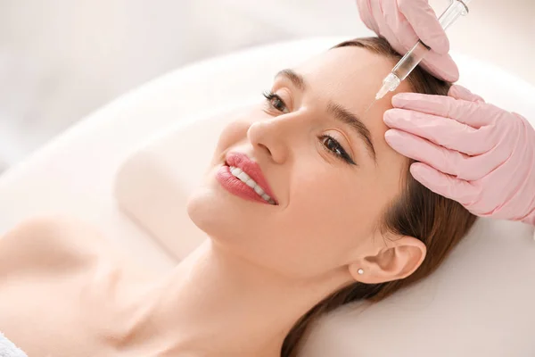 Young woman receiving filler injection in beauty salon — Stock Photo, Image