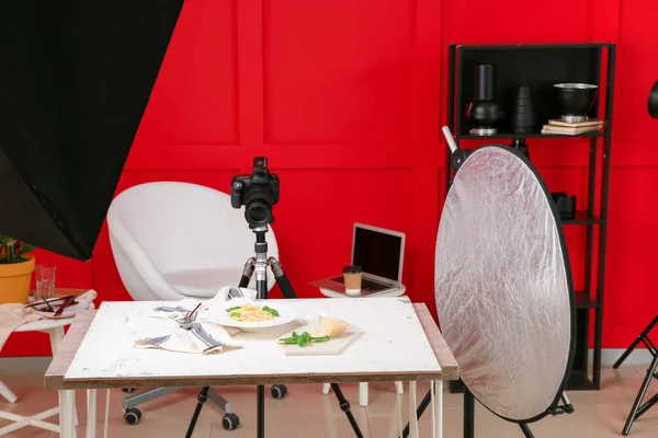 Interior of modern photo studio with professional equipment and food on table — Stock Photo, Image