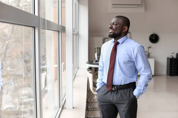 Retrato del hombre de negocios afroamericano guapo cerca de la ventana en la oficina — Foto de Stock