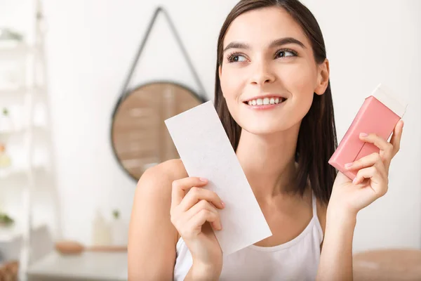 Beautiful young woman with liposoluble wax cartridge in bathroom — Stock Photo, Image