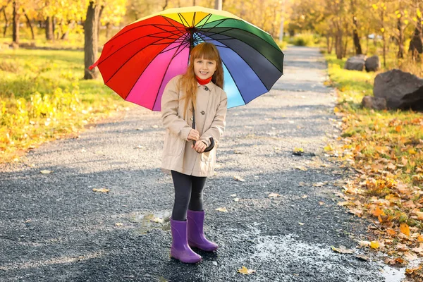 Carina bambina con ombrello nel parco autunnale — Foto Stock