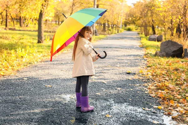 Petite fille mignonne avec parapluie dans le parc d'automne — Photo