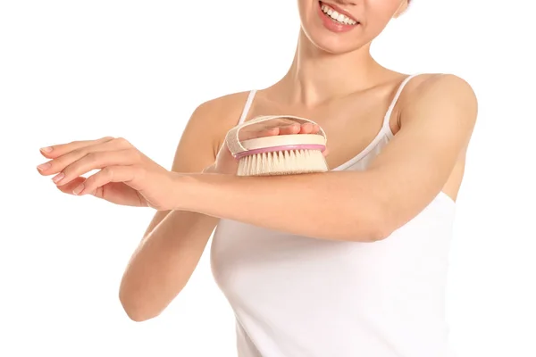 Mulher bonita com escova de massagem no fundo branco — Fotografia de Stock