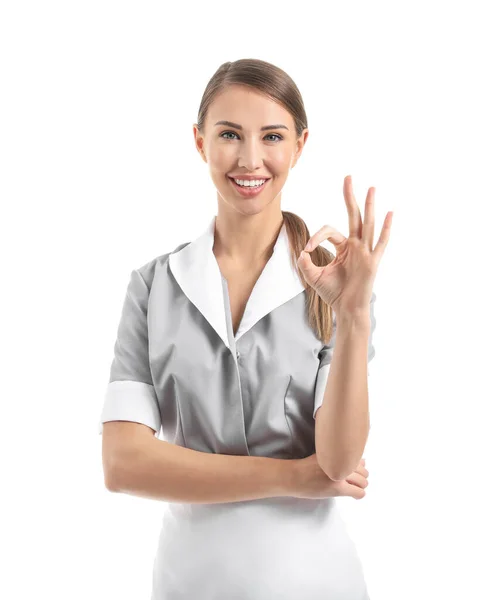 Portrait of beautiful chambermaid showing OK on white background — Stock Photo, Image