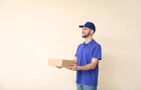 Entrega homem com caixa no fundo de cor — Fotografia de Stock