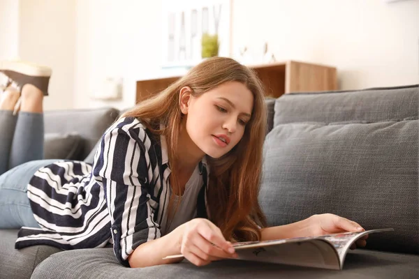 Mujer joven con revista descansando en casa — Foto de Stock