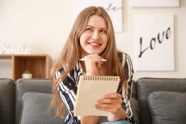 Femme réfléchie avec ordinateur portable à la maison — Photo