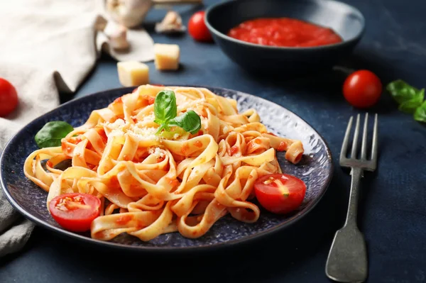 Plato con sabrosa pasta y salsa de tomate sobre fondo oscuro — Foto de Stock