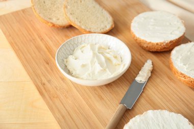 Tahtada lezzetli krem peynirli taze çörekler.