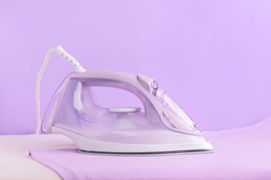 Renk arkaplanında elektrikli ütü ve tahta