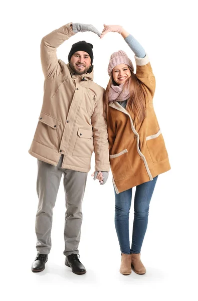 Retrato de pareja feliz en ropa de invierno haciendo forma de corazón con sus manos sobre fondo blanco — Foto de Stock