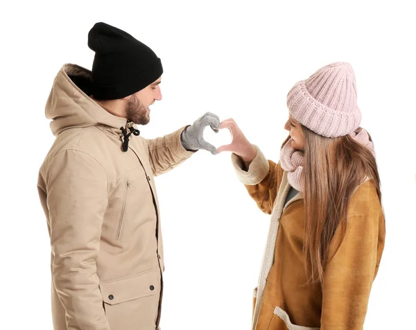 Retrato de pareja feliz en ropa de invierno haciendo forma de corazón con sus manos sobre fondo blanco — Foto de Stock