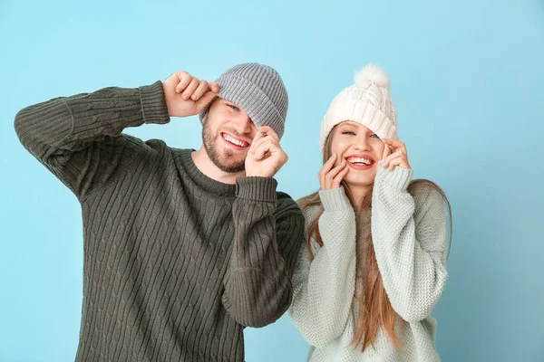 Портрет щасливої пари в зимовому одязі на кольоровому фоні — стокове фото