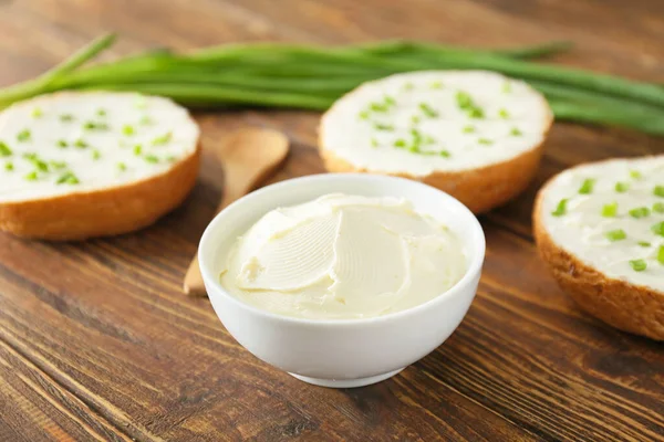 Ciotola con gustosa crema di formaggio sul tavolo — Foto Stock