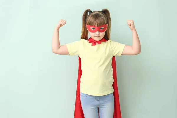 Niña en traje de superhéroe sobre fondo de color. Concepto de feminismo — Foto de Stock