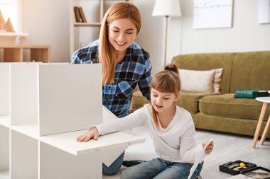 Anne ve küçük kızı evde mobilya montajlıyorlar.