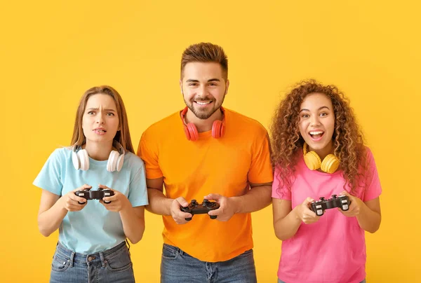 Amigos jugando videojuego sobre fondo de color —  Fotos de Stock