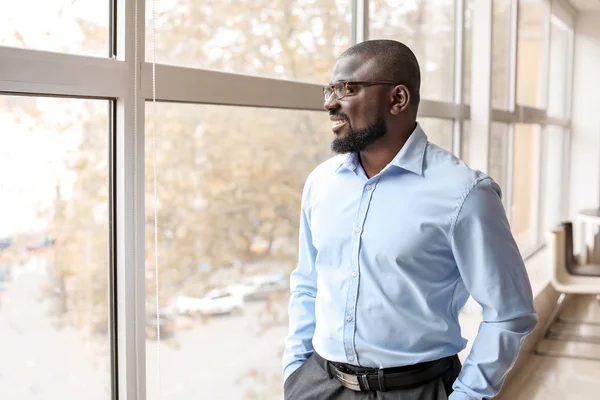 Retrato del hombre de negocios afroamericano guapo cerca de la ventana en la oficina — Foto de Stock