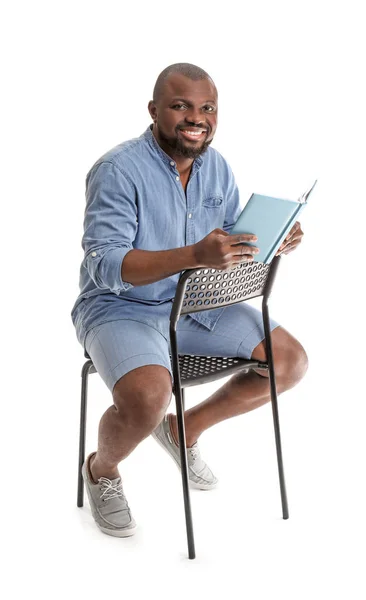 African-American man reading book on white background — Stock Photo, Image