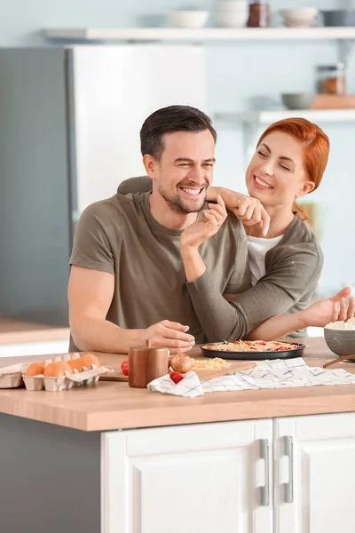 Happy couple cooking together in kitchen — Stock Photo, Image