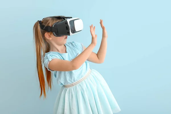 Маленька дівчинка з окулярами віртуальної реальності на кольоровому фоні — стокове фото