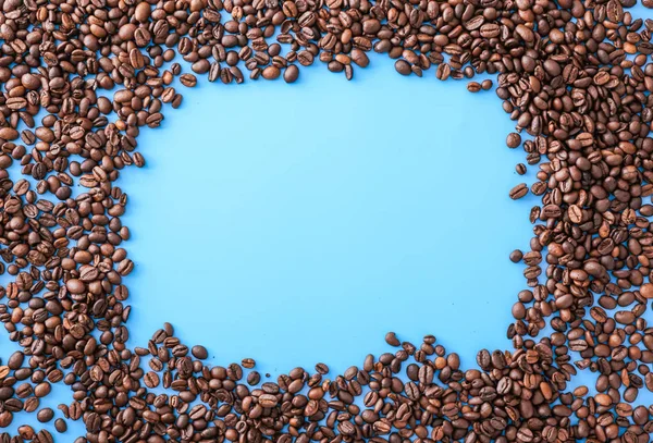 Frame made of coffee beans on color background — Stock Photo, Image