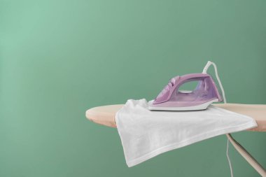 Renk arkaplanında elektrikli ütü ve tahta