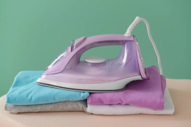 Renk arkaplanında elektrikli ütü ve tahta