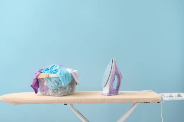 Renk arkaplanında elektrikli ütü ve tahta