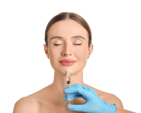 Young woman receiving filler injection against white background — 스톡 사진