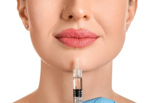 Young woman receiving filler injection against white background, closeup — 스톡 사진