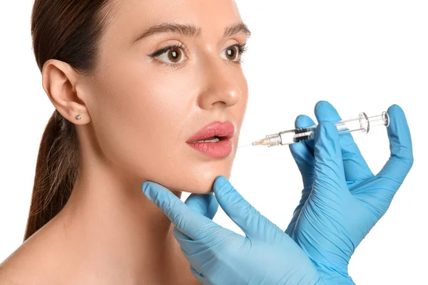 Young woman receiving filler injection against white background — 스톡 사진