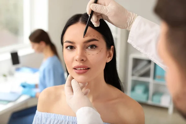 Plastischer Chirurg trägt in Klinik Spuren im Gesicht des Patienten auf — Stockfoto