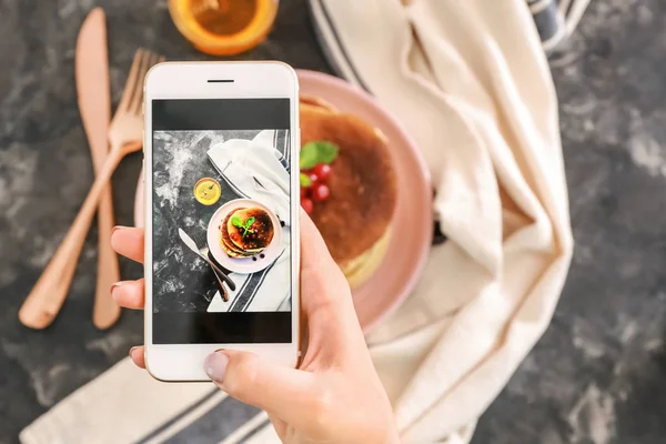 Fotografo di cibo femminile con cellulare che fotografa le frittelle — Foto Stock