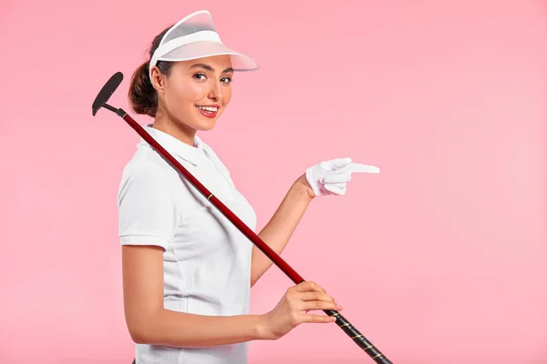 Linda golfista feminina apontando para algo no fundo de cor — Fotografia de Stock