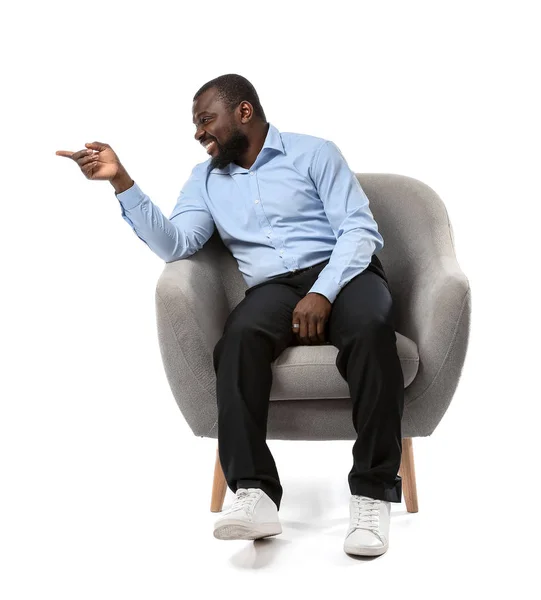 Africano-americano homem sentado em poltrona contra fundo branco — Fotografia de Stock