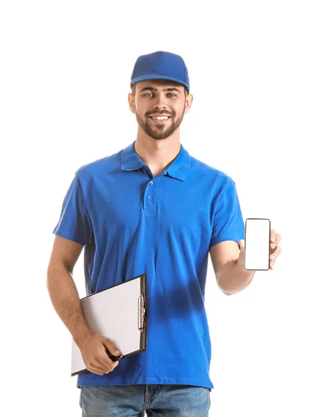 Bonito homem de entrega com telefone celular no fundo branco — Fotografia de Stock