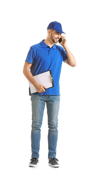 Handsome delivery man talking by phone on white background — Stock Photo, Image