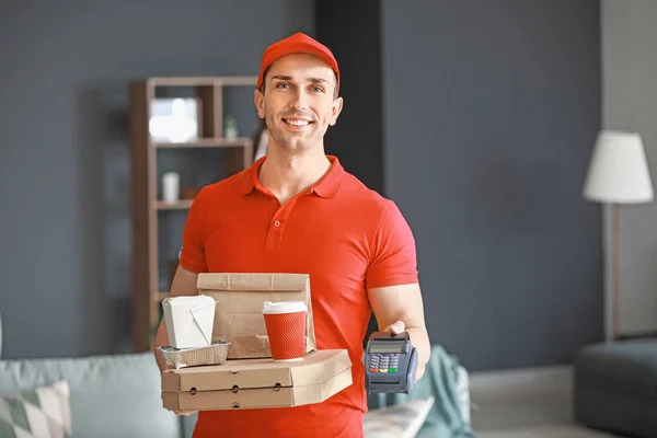 Handsome worker of food delivery service with payment terminal indoors — Stock Photo, Image