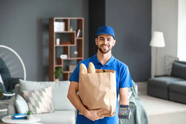 Bonito trabalhador do serviço de entrega de alimentos com terminal de pagamento dentro de casa — Fotografia de Stock