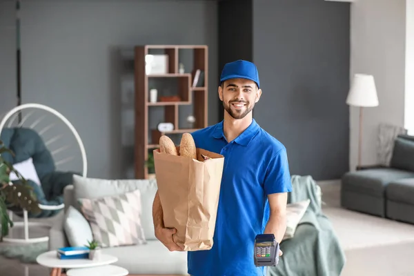 Hermoso trabajador del servicio de entrega de alimentos con terminal de pago en interiores — Foto de Stock