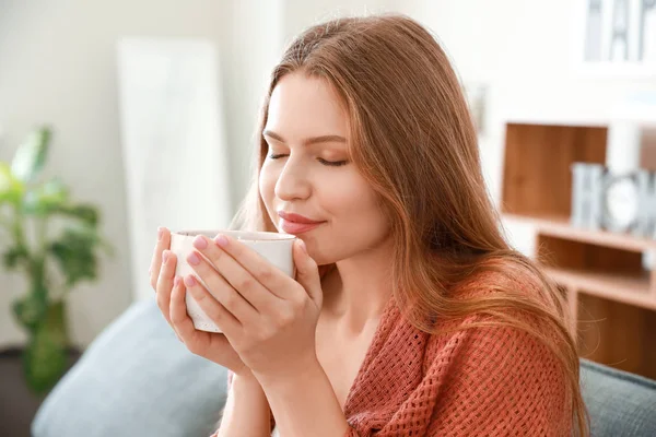 Mujer feliz con taza de té descansando en casa — Foto de Stock