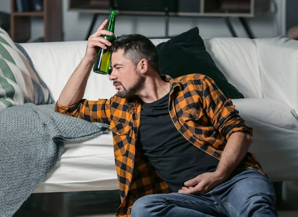 Een volwassen man die thuis bier drinkt. Begrip alcoholisme — Stockfoto
