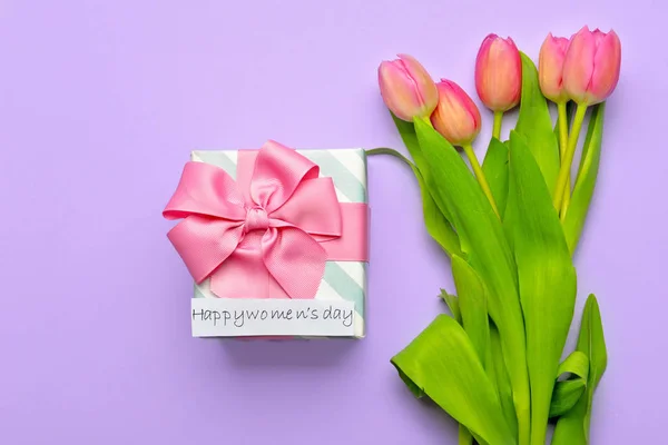 Blommor och gåva till Internationella kvinnodagen på färg bakgrund — Stockfoto