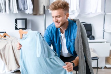 Soyunma odasında şık elbiseli yakışıklı bir adam.