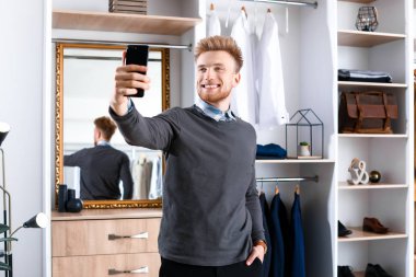 Şık genç adam soyunma odasında selfie çekiyor.