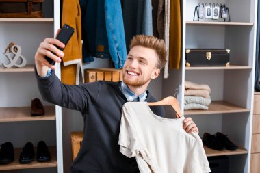 Şık genç adam soyunma odasında selfie çekiyor.